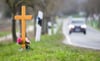 Ein Kreuz zum Gedenken an ein Opfer eines Verkehrsunfalls steht an einer Landstraße.