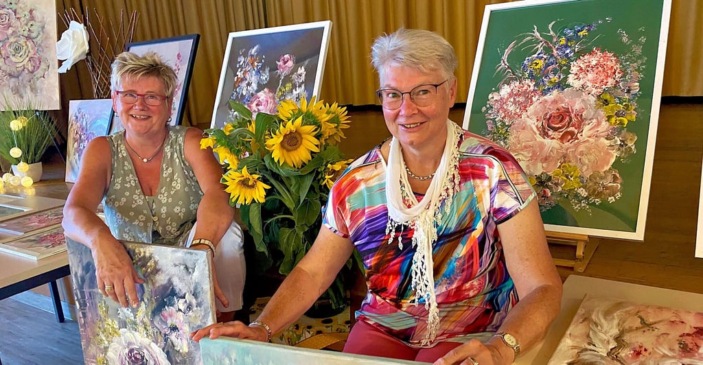 Christina Silabetzschki (links) und Regina Meyer vor den Bildern zur Ausstellung „Blumen sind die Sonne des Lebens“.