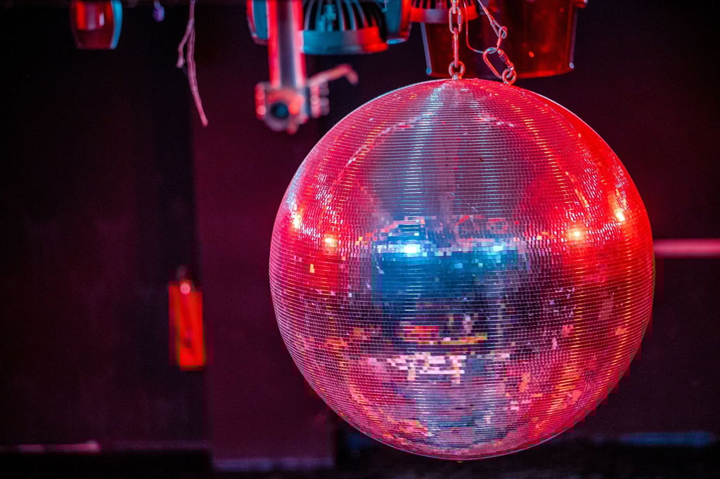 Die farbig beleuchtete Discokugel dreht sich über der Tanzfläche.