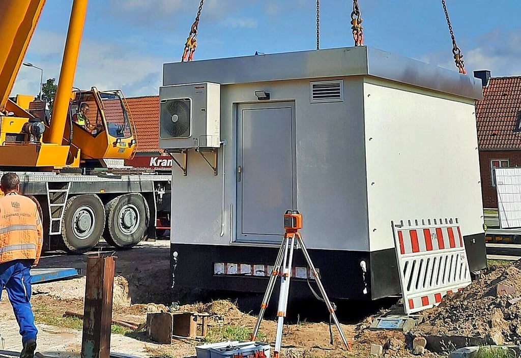 Ein Schwerlastkran hob den gut 30 Tonnen wiegenden Technikcontainer für schnelles Internet im Bereich Wust in die Baugrube.