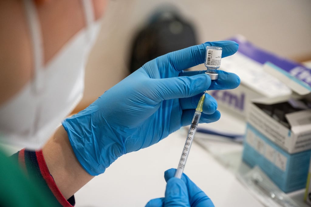 Die Mitarbeiterin eines mobilen Impfteams zieht den Impfstoff von Biontech/Pfizer auf eine Spritze.