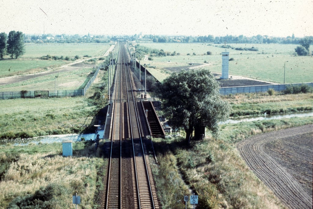 Das Bild zeigt die Grenzanlage an der Eisenbahn-Brücke über die Aller, wie sie in den 1970er Jahren existiert hat. Rechts sind die Mauer und ein Grenzturm auf DDR-Gebiet zu sehen.