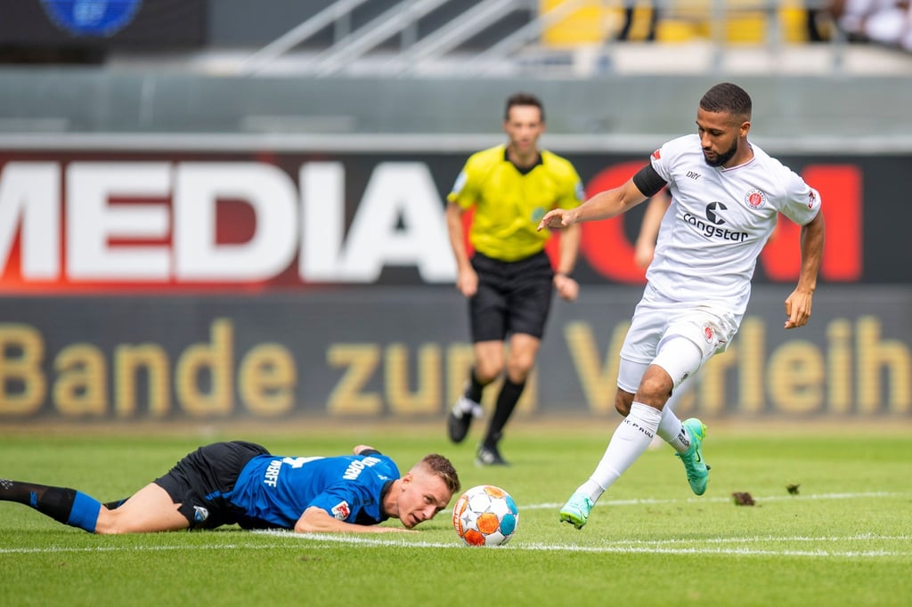 Paderborns Jasper van der Werff (l) und St. Paulis Daniel Kyereh kämpfen um den Ball.