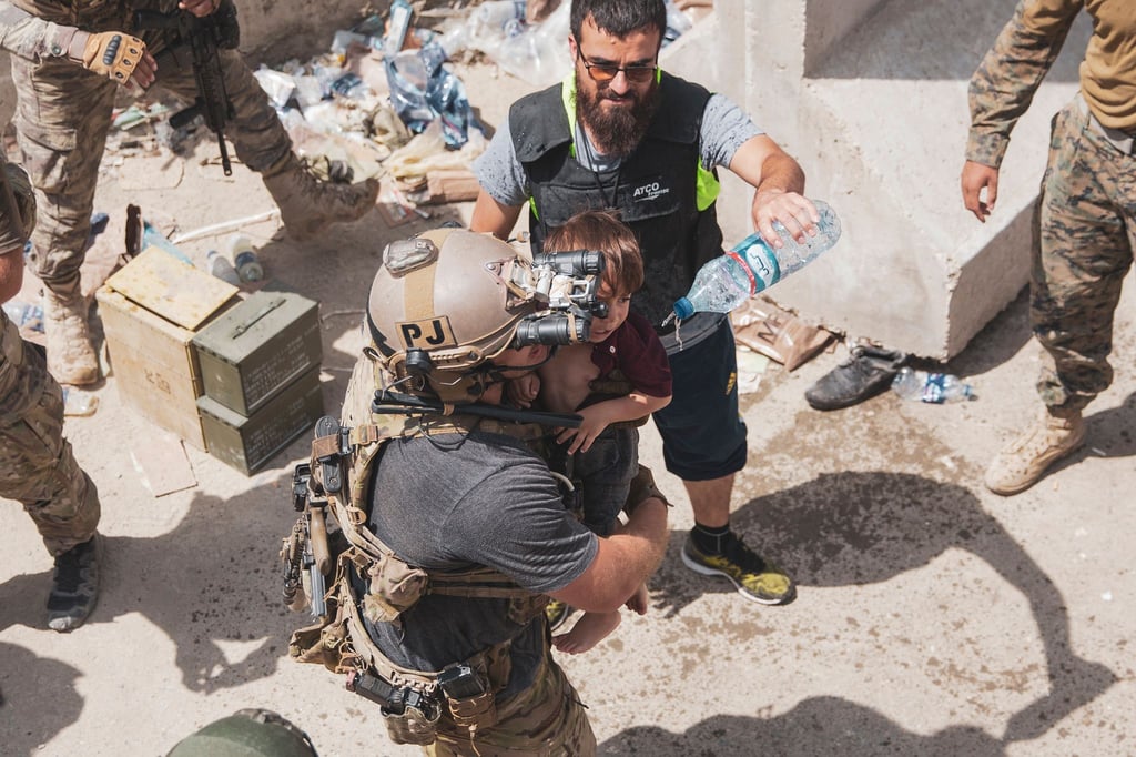 Auf diesem vom US Marine Corps zur Verfügung gestellten Foto trägt ein US-Soldat ein Kind an einem Evakuierungskontrollpunkt am Kabuler Flughafen.