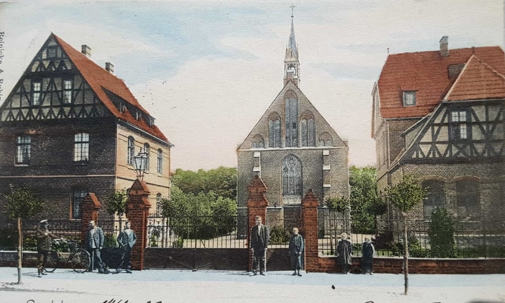 So wie auf dieser alten Postkarte sieht die katholische Kirche heute nicht mehr aus. Ein schwerer Sturm 1972 zerstörte den kleinen Turm auf dem Dach, der auch Dachreiter genannt wurde.