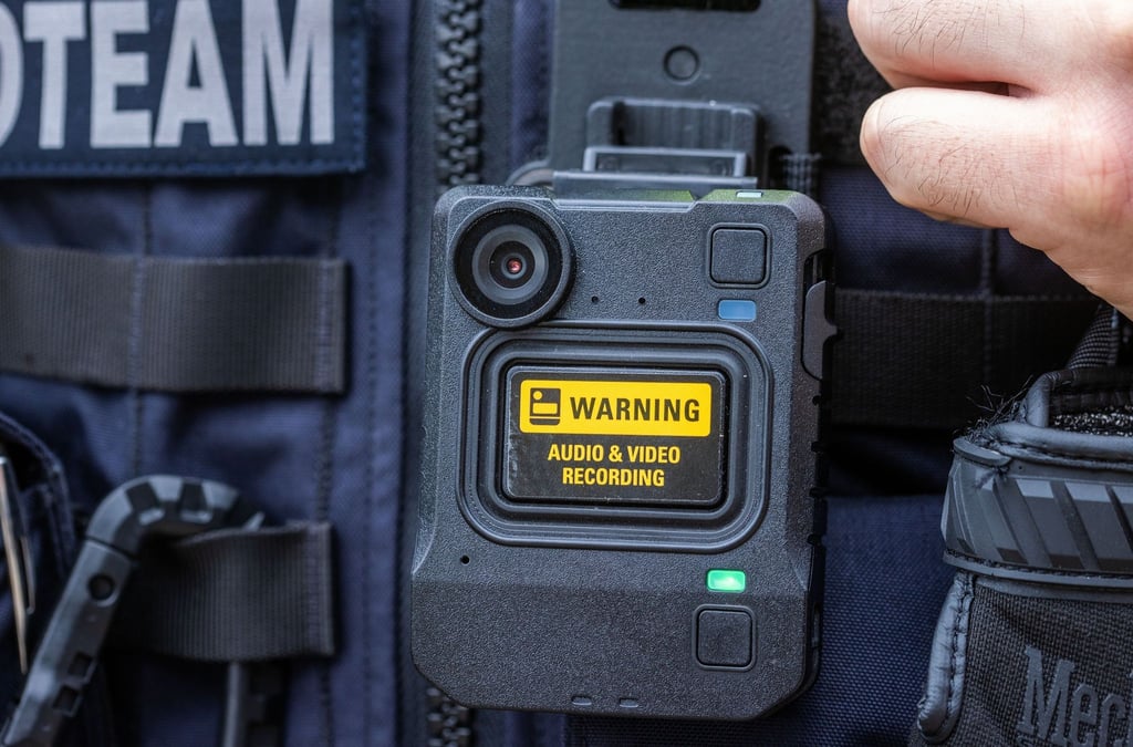 Eine Body-Cam hängt an der Schutzweste einer Polizeibeamtin.