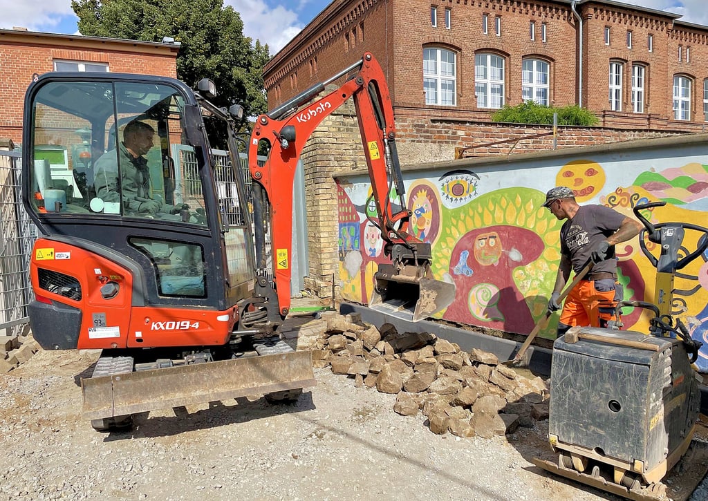 Mike Bergmann und Heiko Ress vom Hecklinger Stadtbaubetrieb sorgen dafür, dass die hintere Schulhof der Grundschule Hecklingen bis zum Schuljahresbeginn im neuen Glanz strahlt.