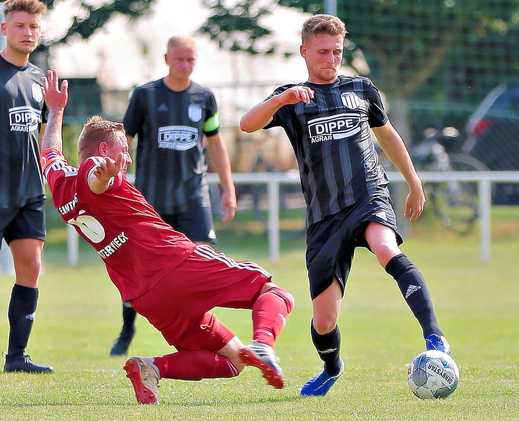 David Wagner (links, Osterwieck) beim Versuch, die Ballannahme von Wulferstedts Christian Schütze zu verhindern.