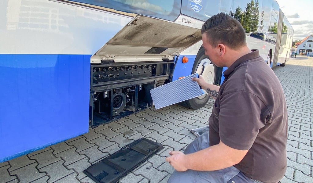 Azubi Pascal Pissor setzt einen der neuen Hepa-Filter in die Lüftungsanlage eines Gelenkbusses der Jessener Personenverkehr GmbH ein.