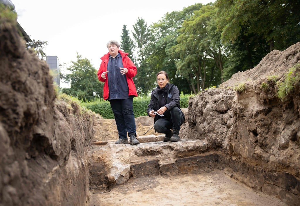 Astrid Tummuscheit, Archäologin und Leiterin der Grabung, und Frauke Witte (r), Museum Sonderjylland in Haderslev, erläutern die Voruntersuchungen des Archäologischen Landesamtes an der Grabungsstelle neben dem Danevirke Museum am Dannewerk.
