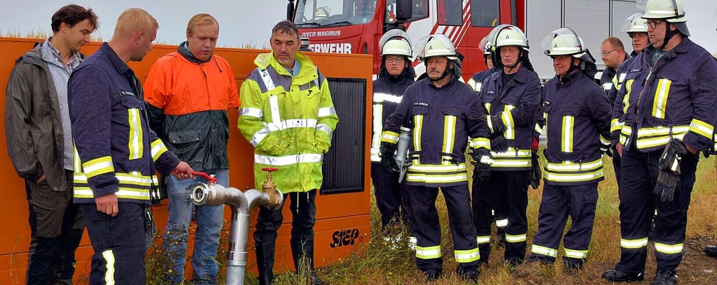 Der Döhrener Wehrleiter Ronny Matschke (2.v.l.) zeigte den Landwirten Henrik Meine (3.v.l.) und Christian Lübke (4.v.l.) sowie den Kameraden, wie das Übergangsstück am Tiefbrunnen eingesetzt wird.