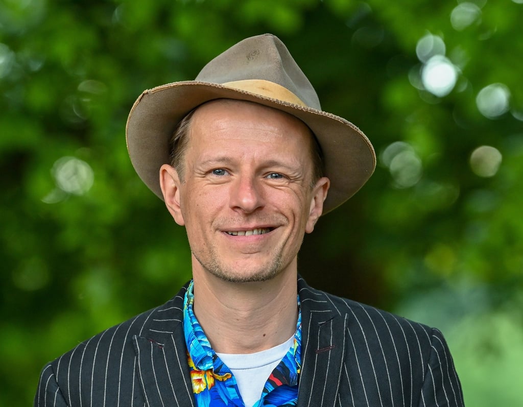 Alexander Scheer, Schauspieler, Musiker, Sänger, lächelt in die Kamera.