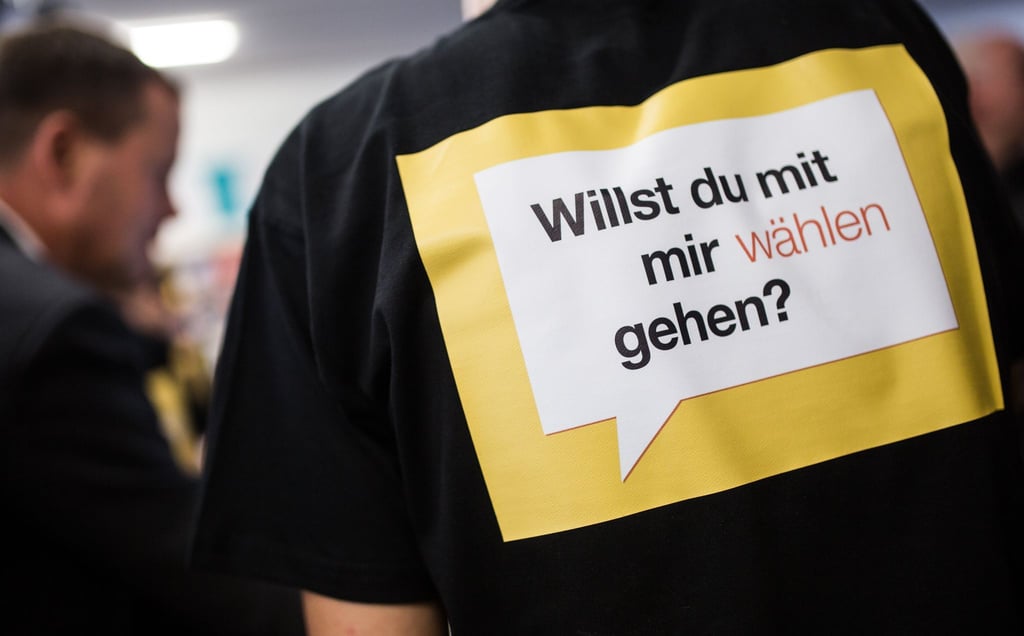 Auf dem T-Shirt eines Wahlhelfers steht "Willst du mit mir wählen gehen?".