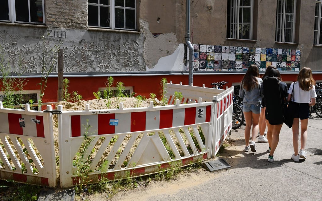 Absperrungen vor einer maroden Wand an einer Berliner Schule.