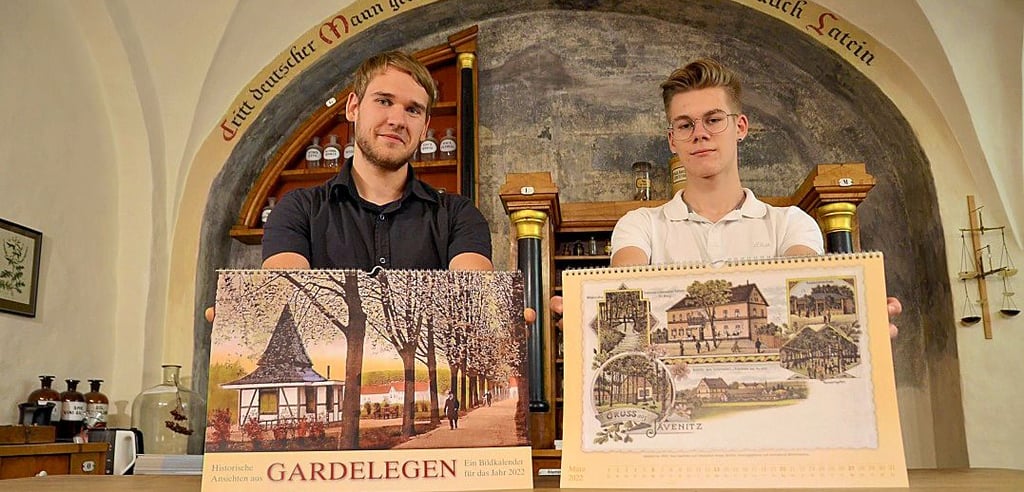 Fabian Krüger (links) und Yannic Fröhlich mit dem neuen  Kalender 2022 mit alten Gardelegener Ansichten. Er kann in der Tourist-Information erworben werden.