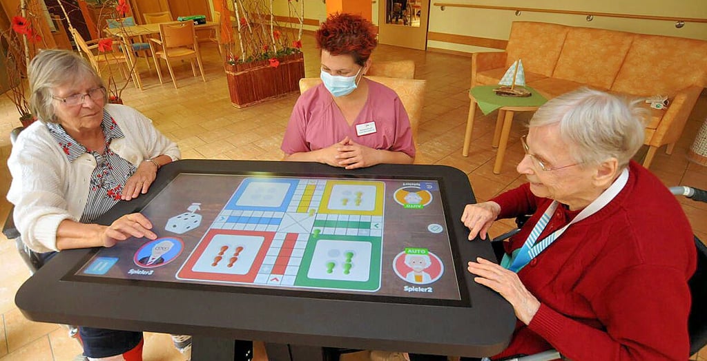 Die 80-jährige Annemarie Krompholz, Pflegerin Mauela Busch sowie die 93-jährige Hannelore Zenner (v.l.) spielen eine digitale Partie ?Mensch ärgere Dich nicht?.