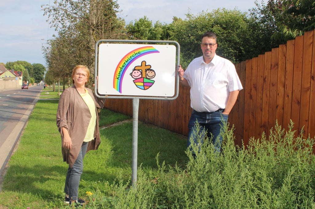 Nicole Binder von Gemeindekirchenrat und Ortsbürgermeister Mathias Stempor freuen sich auf den Neuanfang der Kinderkirche in Ackendorf. Die Hinweisschilder wurden an den Ackendorfer Ortseingängen erst kürzlich aufgestellt.
