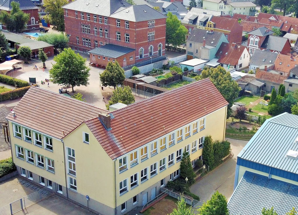 Blick über das Gelände der Grundschule am Hain in Osterburg. Für das Altgebäude (im Hintergrund ) zeichnen sich Sanierungsarbeiten an der Fassade ab.