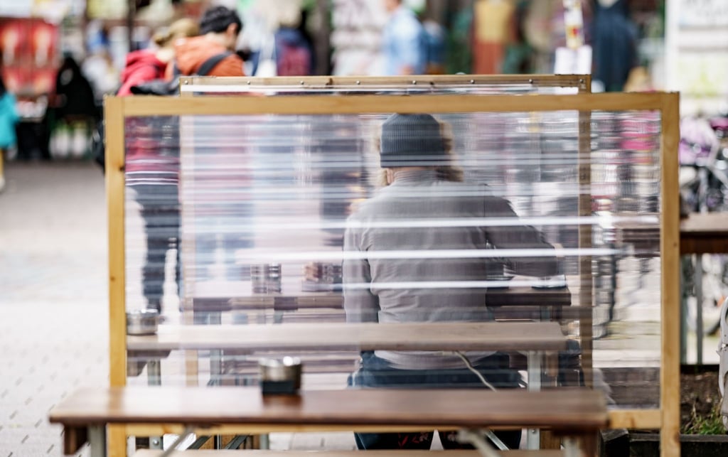 Gäste eines Restaurants warten zwischen Plexiglas-Trennscheiben auf ihre Bestellung. In Hamburg gilt ab dem Wochenende die sogenannte 2G Regelung.