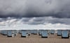 Dunkle Wolken ziehen über den Ostseestrand von Warnemünde. Sommerliches Wetter ist vorerst nicht in Sicht.