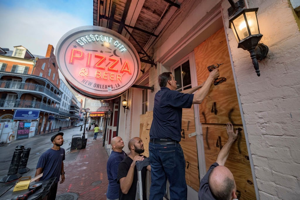 Die Scheiben eines Restaurants in New Orleans werden mit Holzpanelen vor der Ankunft des Hurrikans „Ida“ geschützt.