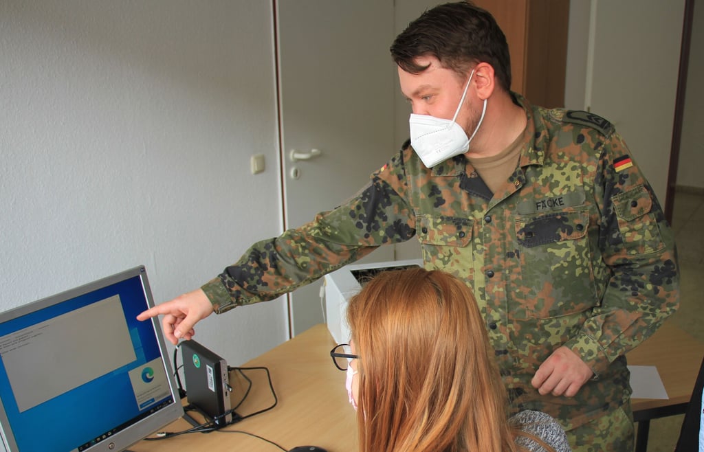 Ein Soldat aus dem Organisationsbereich Cyber-und Informationsraum der Bundeswehr weist Angehörige der Landkreisverwaltung in der Außenstelle Köthen in die neue
Grundinstallation der Arbeitsplatzrechner ein.