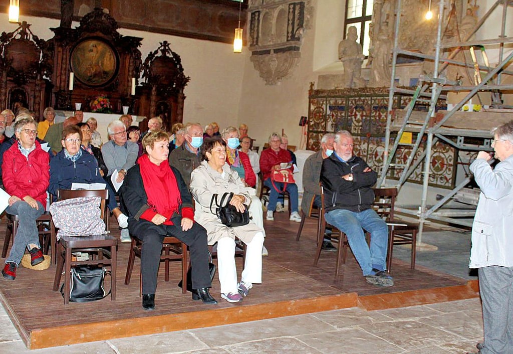 Die Besucher hatten neben den Baugerüsten zur Epitaphien-Restaurierung Platz genommen. Hildegard Bernick (rechts) übernahm die Begrüßung.