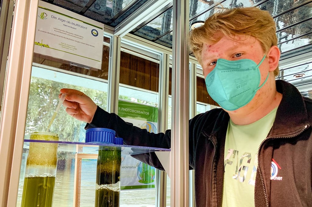 Freiwilliger Tim Gabriel zapft frische Algen zum Mikroskopieren aus dem Reaktor.