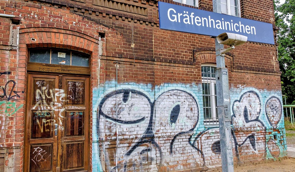Am Bahnhofsgebäude sind großflächige Schmierereien auf die Ziegel gemalt.