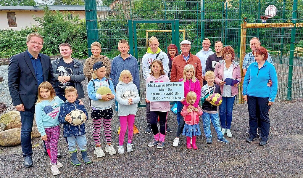 Zur Einweihung schaut neben Kindern und Mitarbeitern der Jugendscheune Wendhusen auch Bürgermeister Maik Zedschack (links) bei Ehepaar Wilsdorf (rechts) vom Klostercamping Thale vorbei. Das Schild mit den Nutzungszeiten wird demnächst noch am Zaun um dem Bolzplatz angebracht.