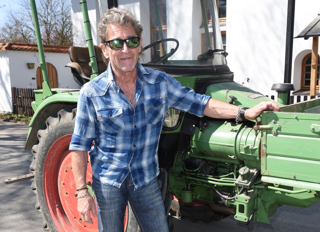 Der Musiker Peter Maffay steht auf Gut Dietlhofen an seinem Traktor.