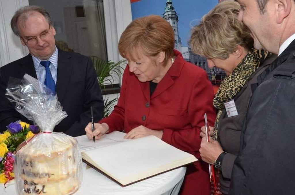 Versöhnung in Salzwedel: nachdem Angela Merkel die Stadt "abgehängt" genannt hatte, leistete sie 2014 Abitte und durfte sich ins Goldene Buch der Stadt eintragen. Rechts Bürgermeisterin Sabine Danicke, links Ministerpräsident Rainer Haseloff. Vorn das Salzwedeler Markenzeichen - der Baumkuchen.