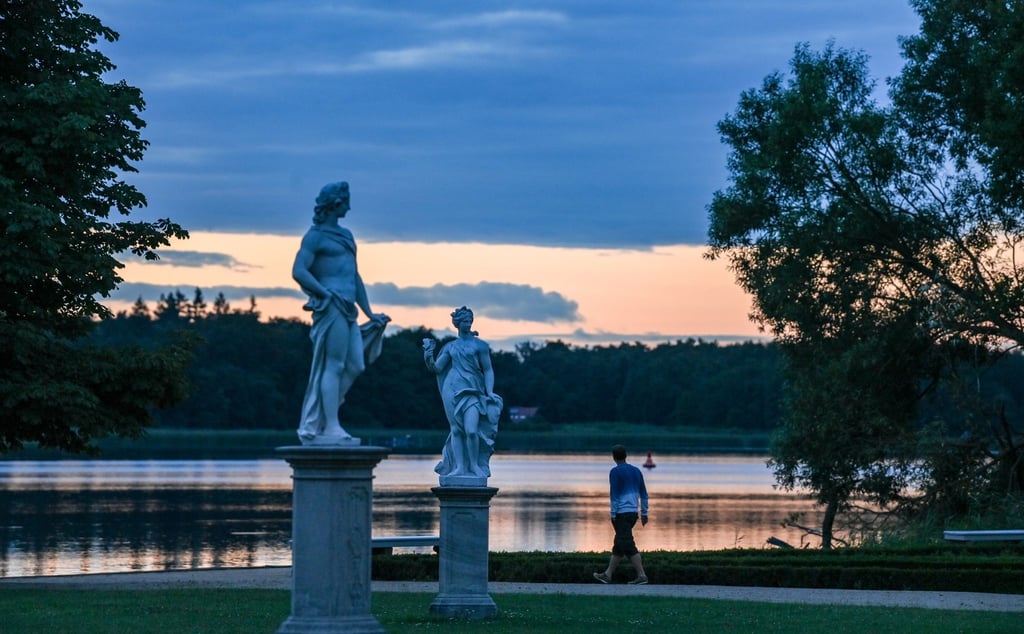 Abendstimmung nach dem Sonnenuntergang hinter dem Skulpturen im Lustgarten über dem Grienericksee.