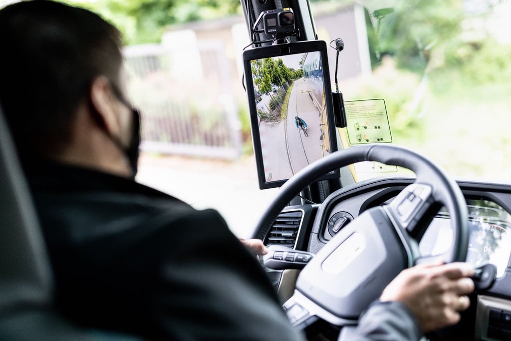 Ein Radfahrer ist bei einem Pressetermin zur Vorführung vom digitalen Spiegelersatzsystem „MAN OptiView“ im digitalen Außenspiegel eines Lastwagen zu sehen.