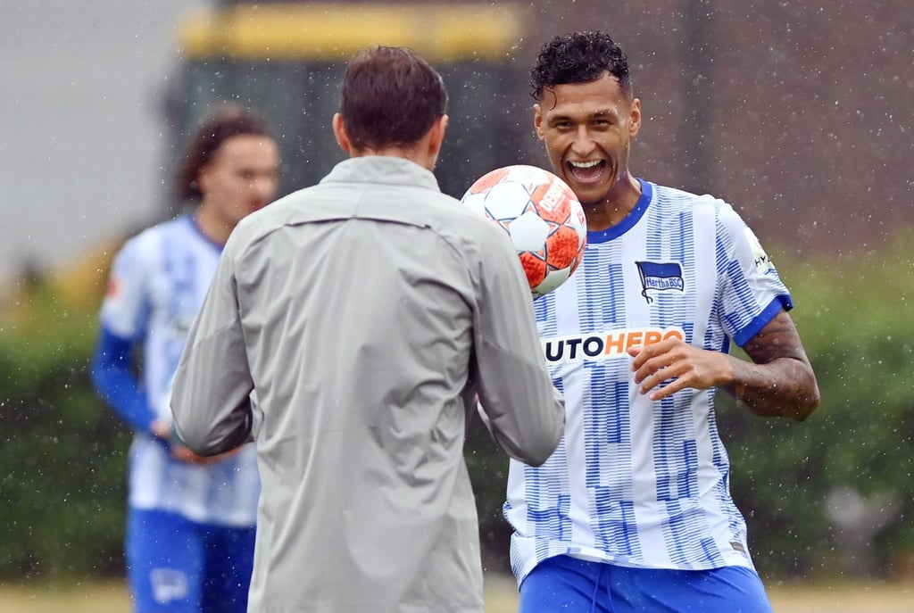 Davie Selke (r) lacht beim Hertha-Training im Regen.
