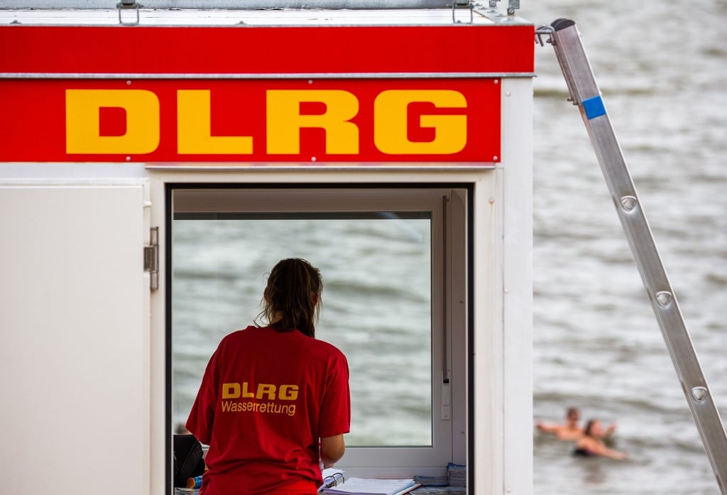 Eine Rettungsschwimmerin der DLRG steht vor dem Fenster eines Wachturms.