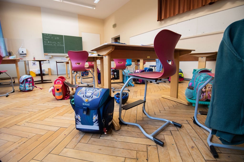 Schulranzen stehen in einem Klassenraum.