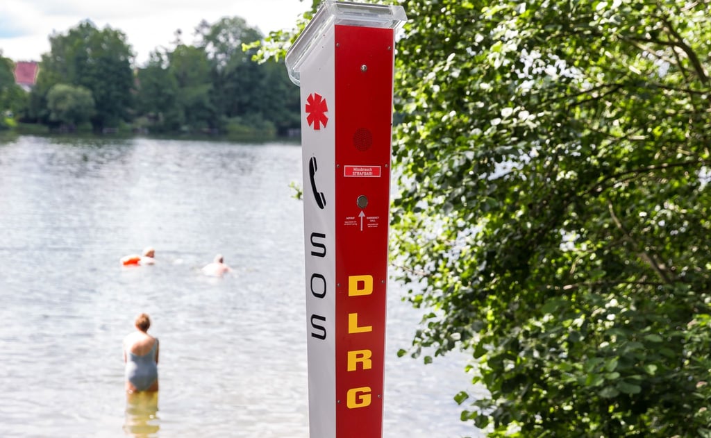 Eine SOS-Notrufsäule der DLRG steht an einer unbewachten Badestelle eines Sees.