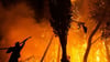 Griechenland, Athen: Ein Feuerwehrmann hält einen Wasserschlauch während der Löscharbeiten eines Waldbrandes im Norden von Athen. Die Feuerwehr kämpft unermüdlich, um die Brände einzudämmen, die in ganz Griechenland ausgebrochen sind. 
