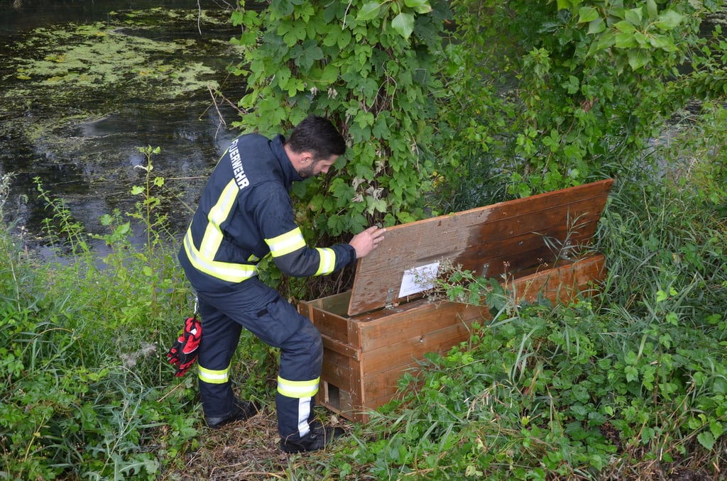 Ein Feuerwehrmann kontrolliert eine der aufgestellten Rückzugskisten am Fluss Ohre.