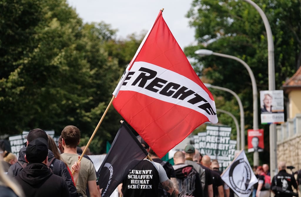 Teilnehmer einer rechten Demonstration gehen mit Transparenten und Fahnen eine Straße entlang. Eine Gegendemonstration mit 1000 angemeldeten Teilnehmern zog zuvor durch Weimar.