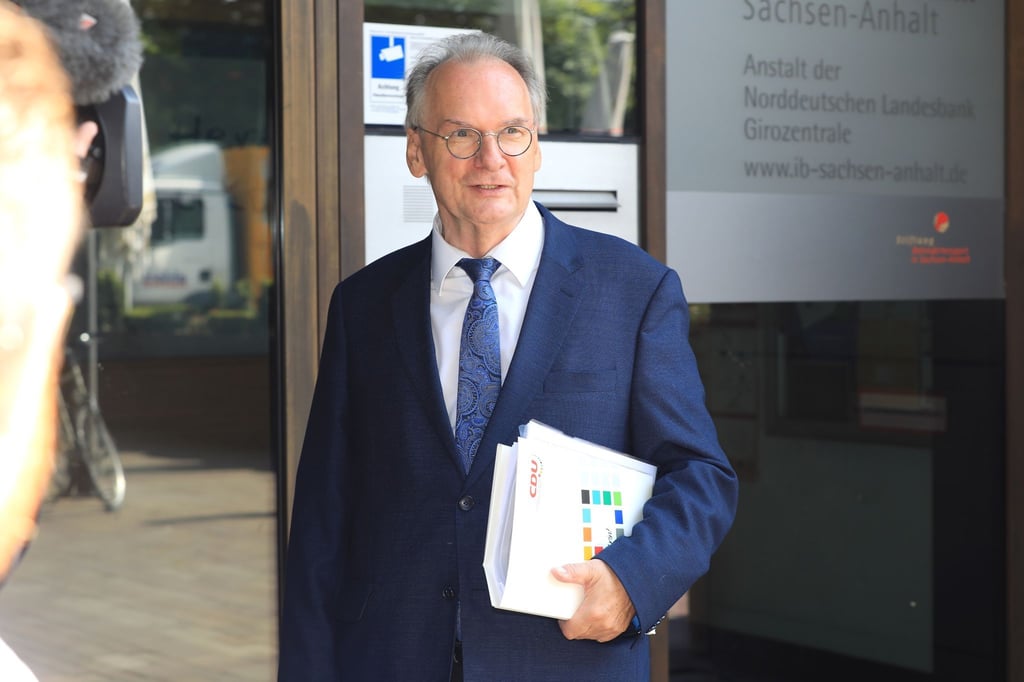 Ministerpräsident Reiner Haseloff (CDU) steht am Eingang eines Bürogebäudes.