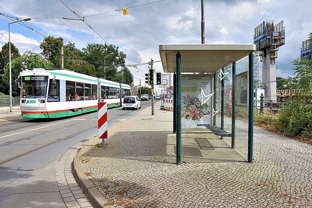 Die Straßenbahn 4 rollt an dem Zollhaus-Wartehäuschen auf dem Werder vorbei. Am Rande wächst der neue Pylon.