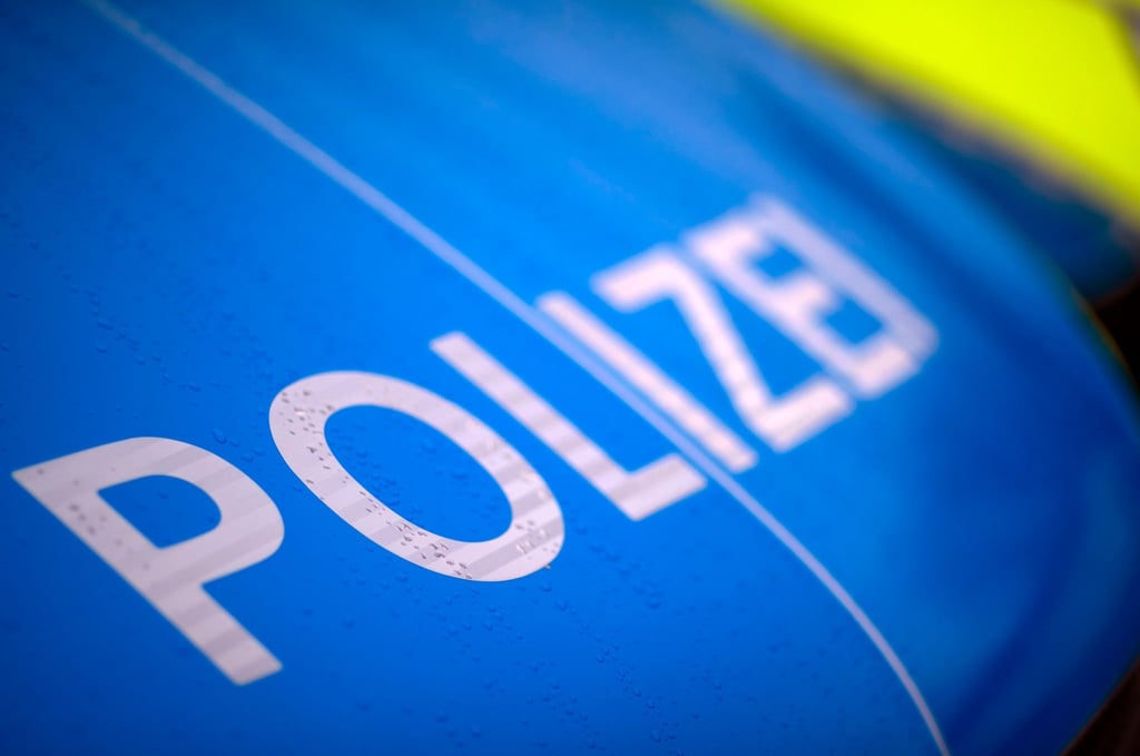 Der Schriftzug „Polizei“ steht auf einem Streifenwagen.