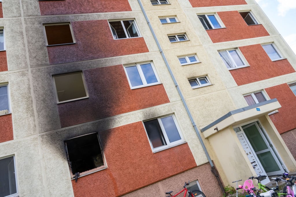 Ein zerstörtes Fenster ist nach dem Brand im 1. Stock eines Mehrfamilienhauses zu sehen.