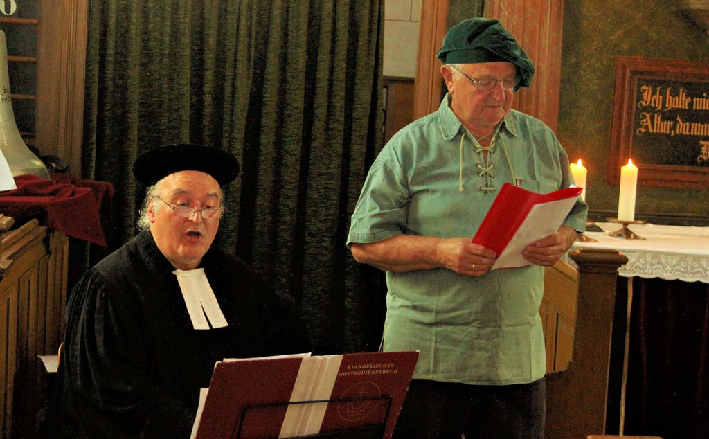 Pfarrer Johannes Könitz und Klaus-Dieter Balko tragen am Sonnabend den Bänkelgesang zum Dorfbrand von 1727 in der Meitzendorfer Kirche vor.