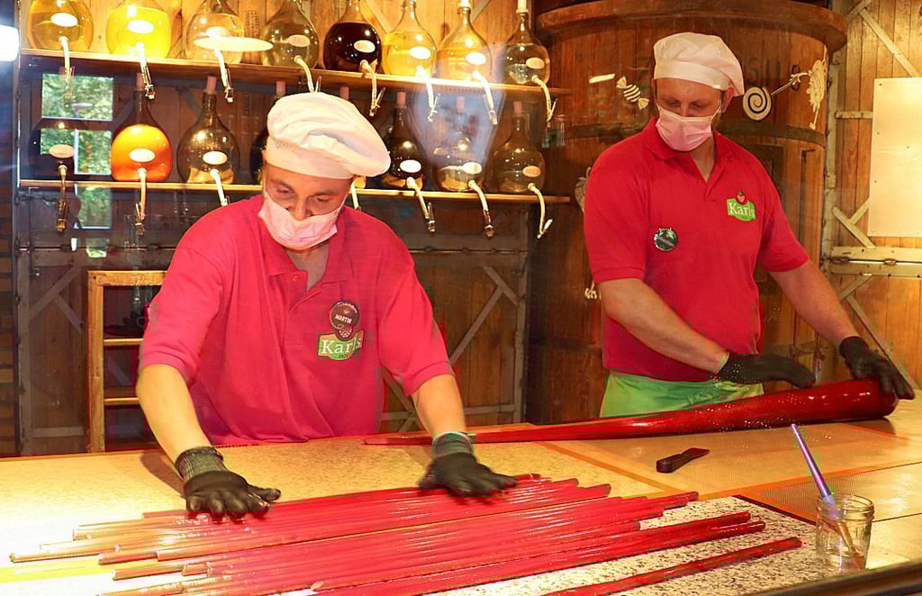 Martin und Sebastian (v. li.) zeigen in der Schaumanufaktur, wie aus den langen Zuckerstangen die Bonbons entstehen. 