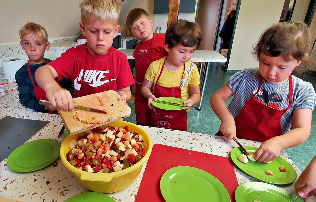 Till gibt das klein geschnittene Obst in die fast volle Schüssel. In der Kita „Regenbogenland“, die gleichzeitig Mehrgenerationenhaus ist, gibt es eine Mitmachküche. Sie steht nicht nur den Kindern zur Verfügung, die diesmal einen Obstsalat gemacht haben.
