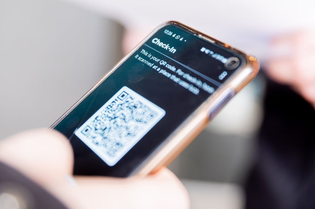 „Check-In“ steht am Eingang eines Bekleidungsgeschäftes in der Luca-App einer Person.