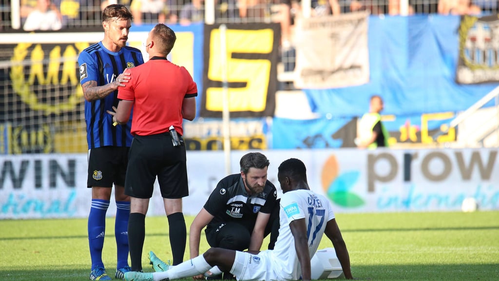 Magdeburgs Sirlord Conteh stitz nach einem Foul von Dennis Erdmann (l.) am Boden.